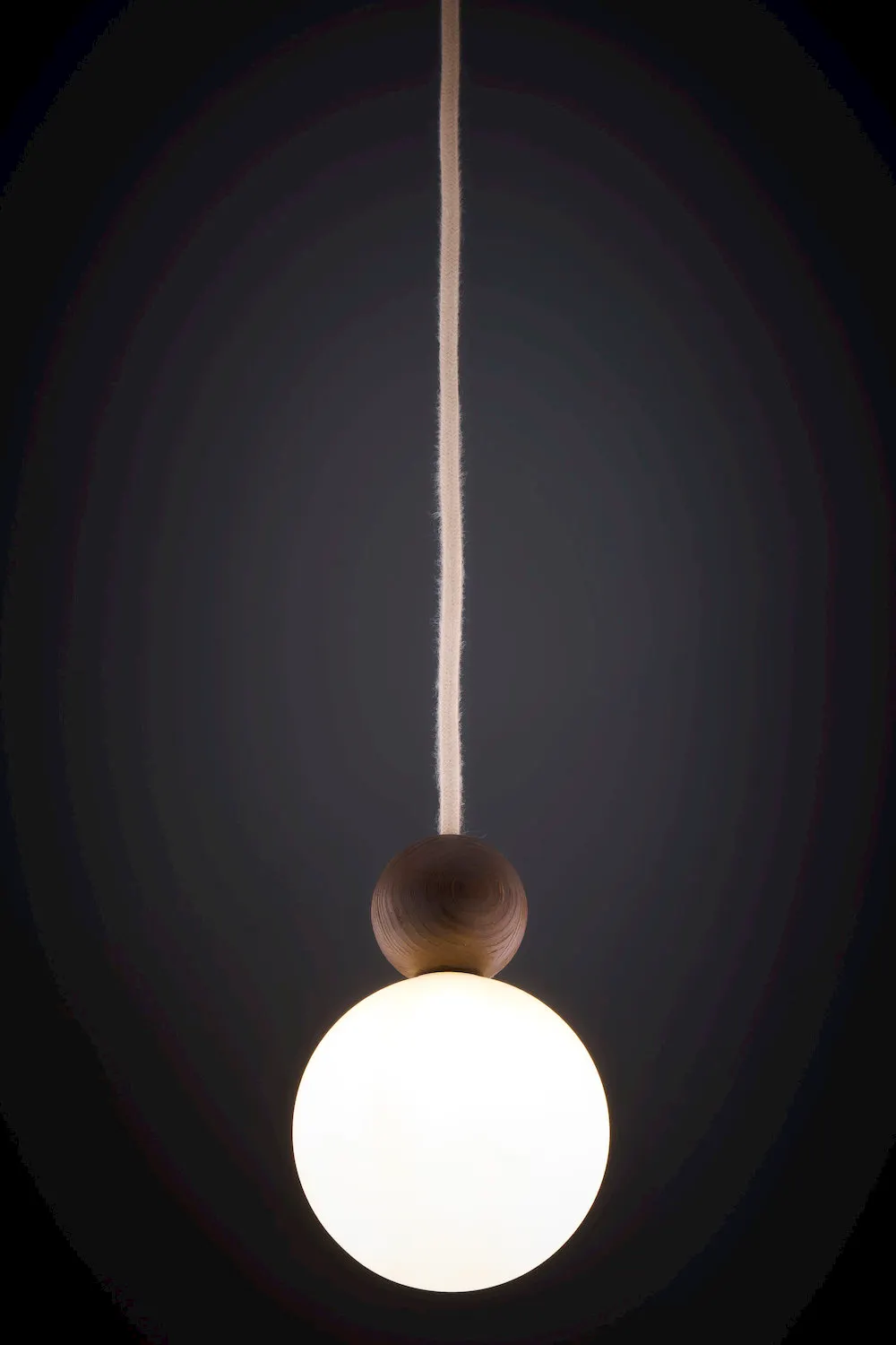 lampa wisząca, kula, drewniana osłona, opałka, glowająca żarówka