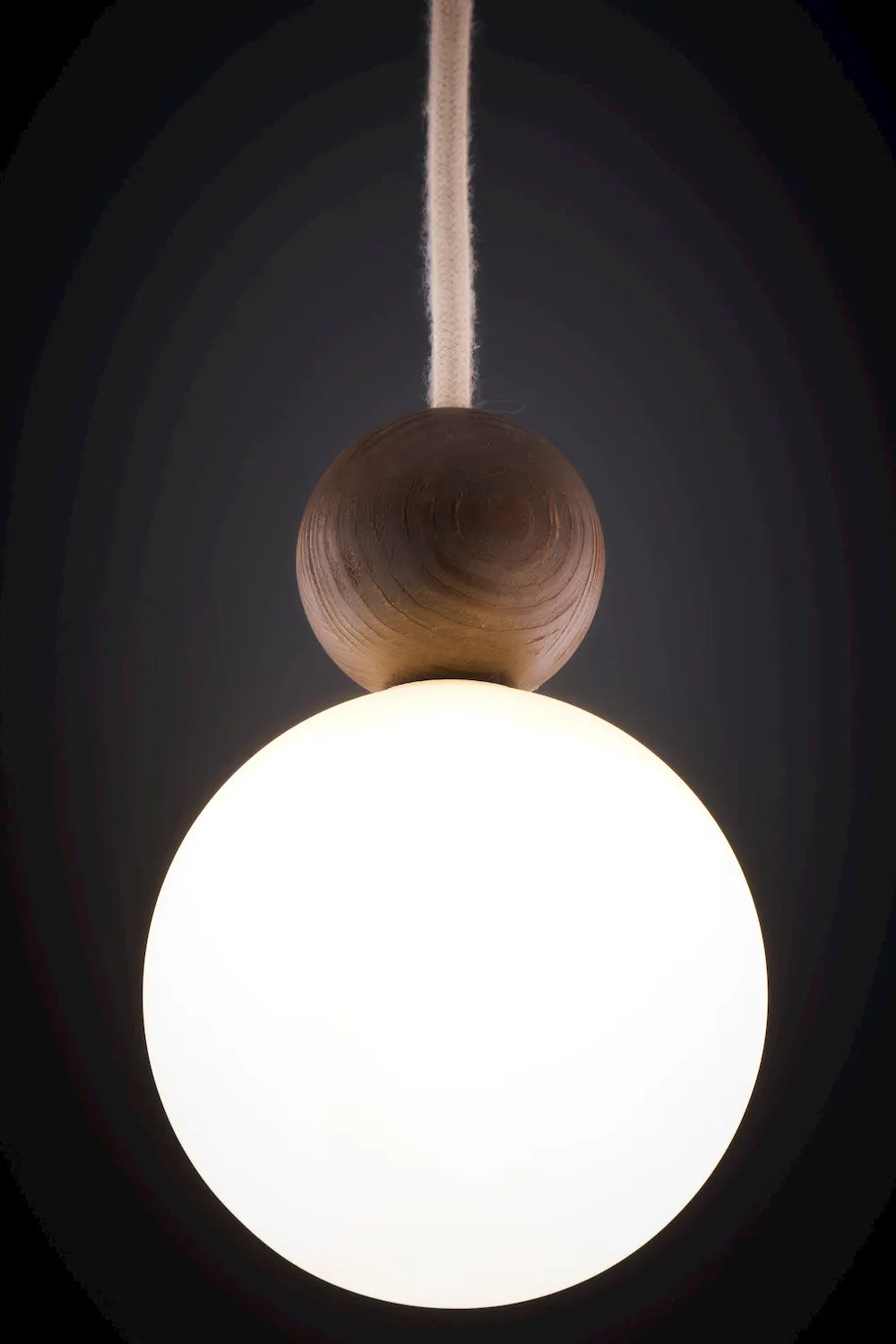 lampa wisząca, kula ceramiczna, drewniany element, przewodowy montaż, emisja światła