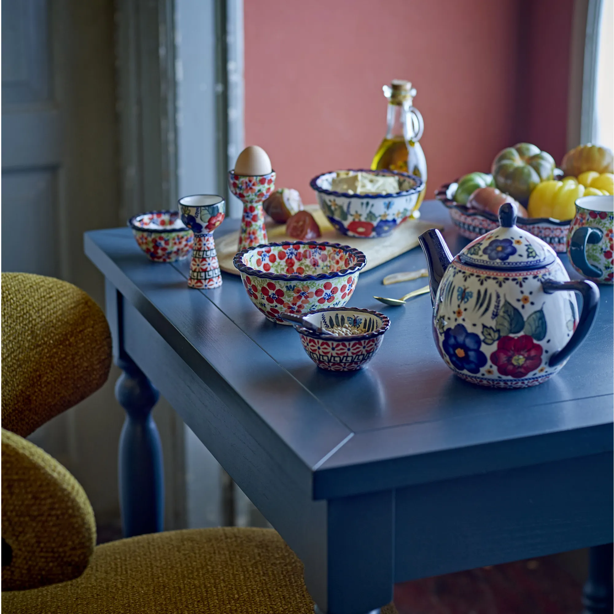 ceramic bowls, egg cup, teapot, blue table, fruit on table