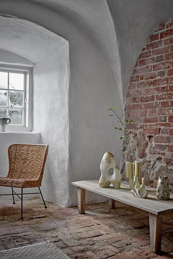 sitaszka, kinkiet, wysoka żerdka?, ogrzewanie?, indoor decor, stone floor, brick wall, wooden bench, rattan chair