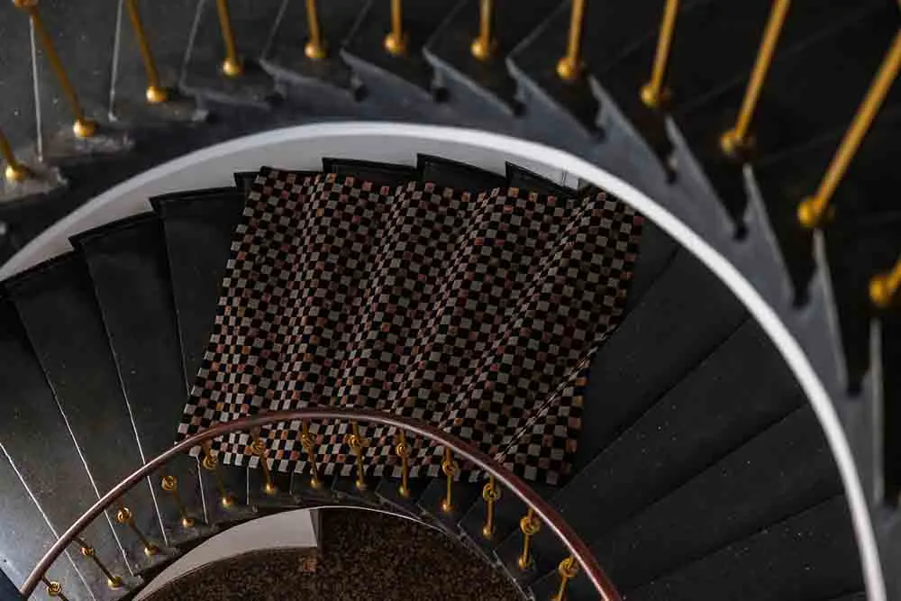 spiral stair, black stairs, checkered pattern, railings, interior design