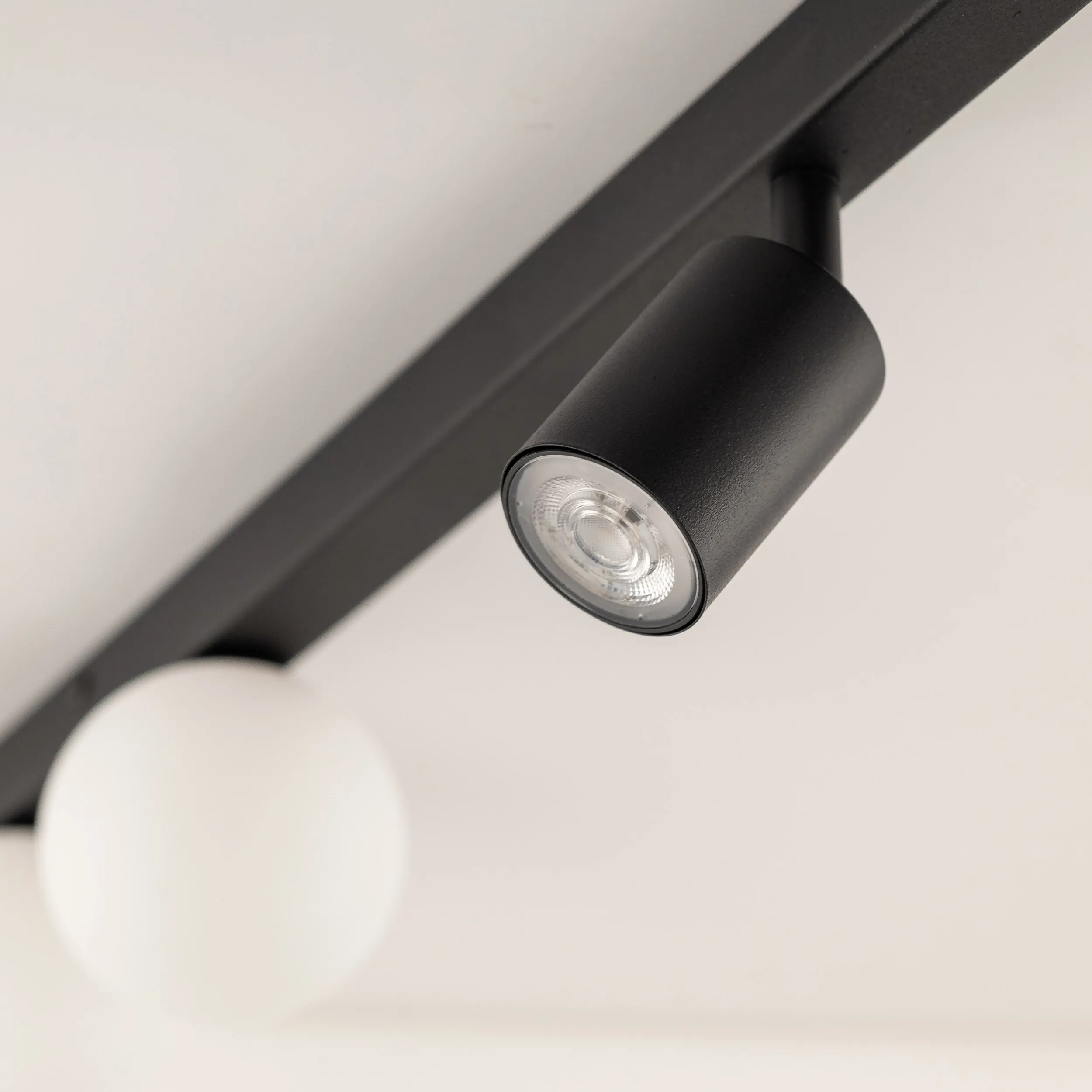 Lampa sufitowa VOX czarna z regulowanymi halogenami oraz białymi okrągłymi szklanymi kloszami 115x15x14cm - TK_10002