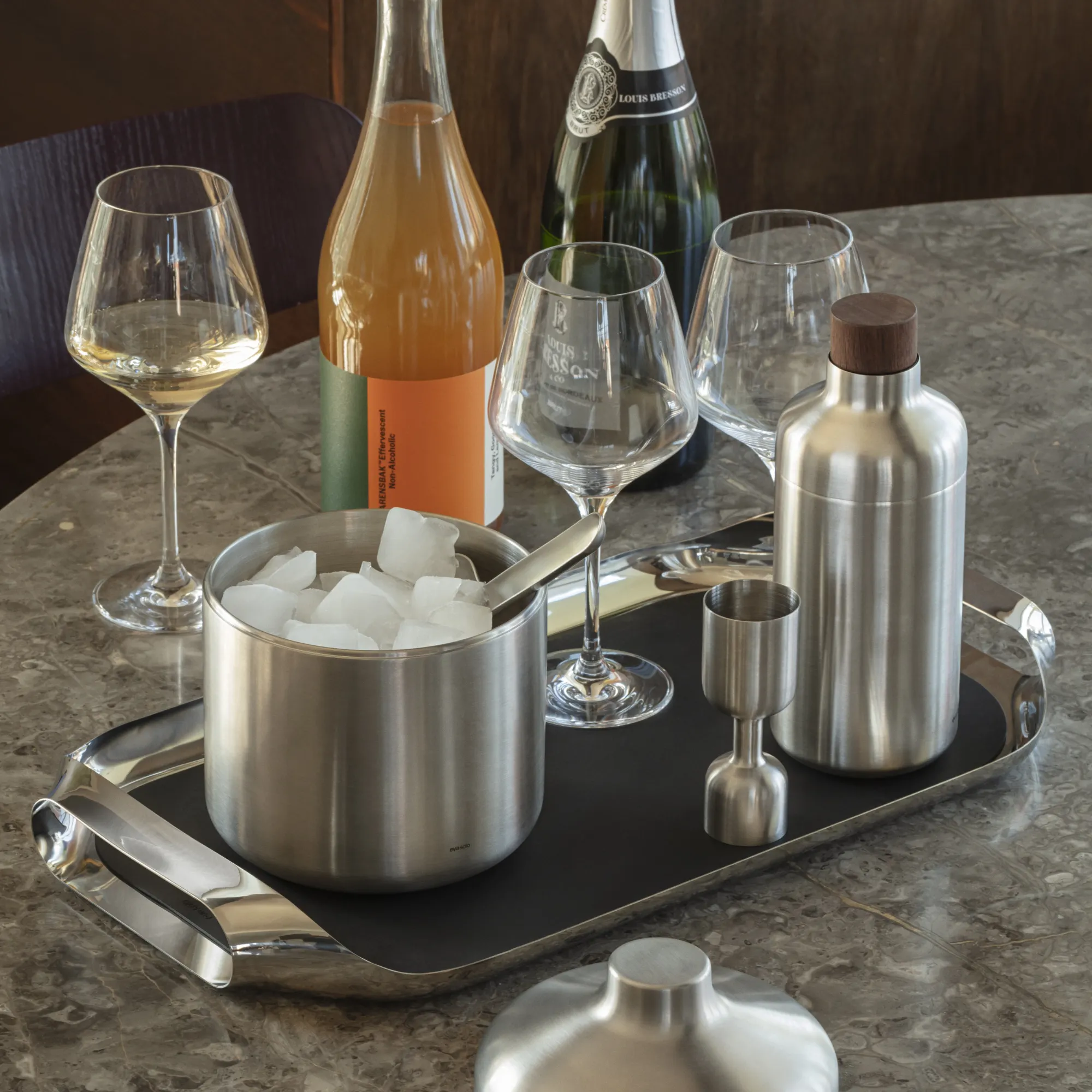stolikowy zestaw do serwowania, naczynie ze stali, kryształowe kieliszki, butelka wina, kubek/miarka stołowa