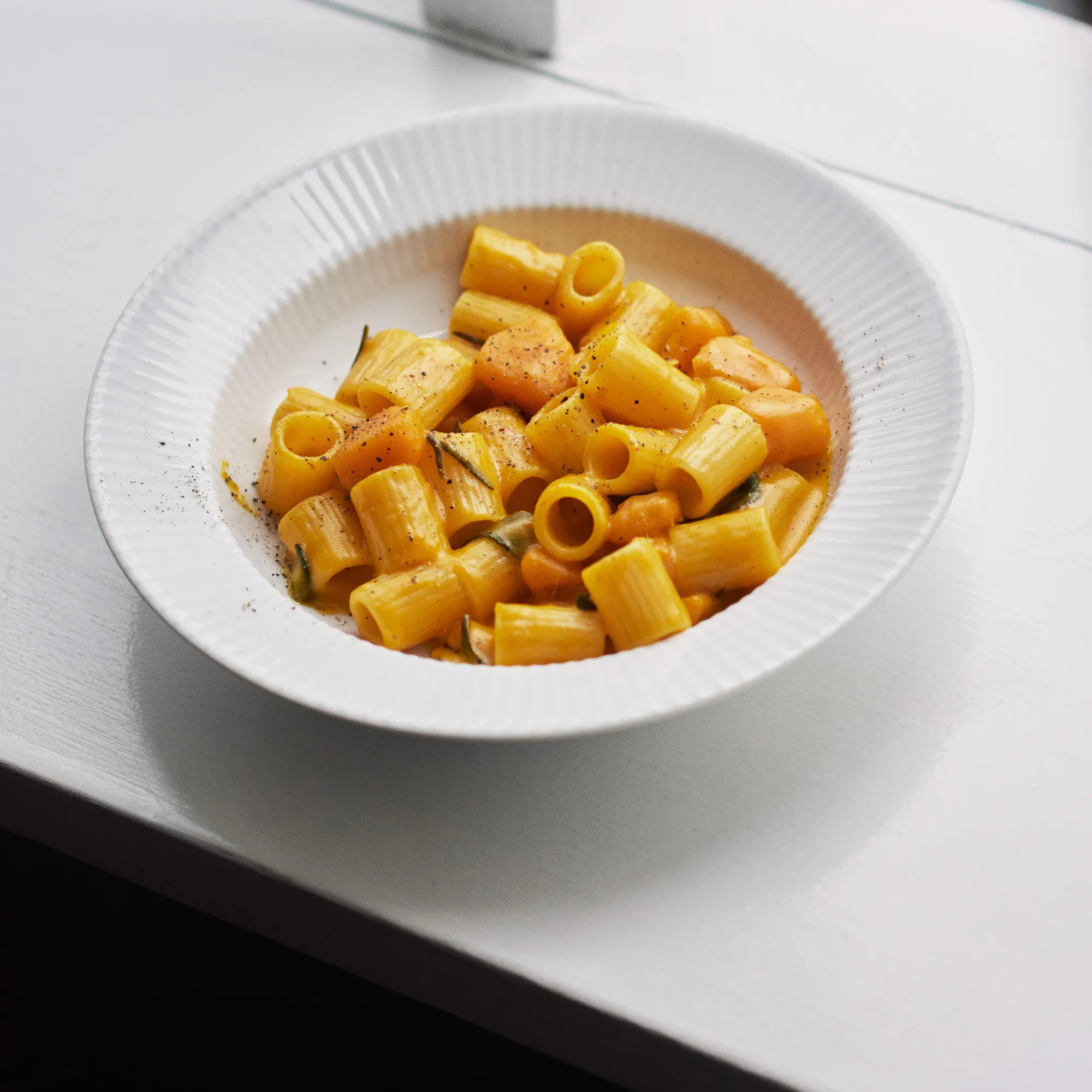 image makaron rigatoni, sos pomidorowy, delikatne danie, kolor pomarańczowy, na talerzu