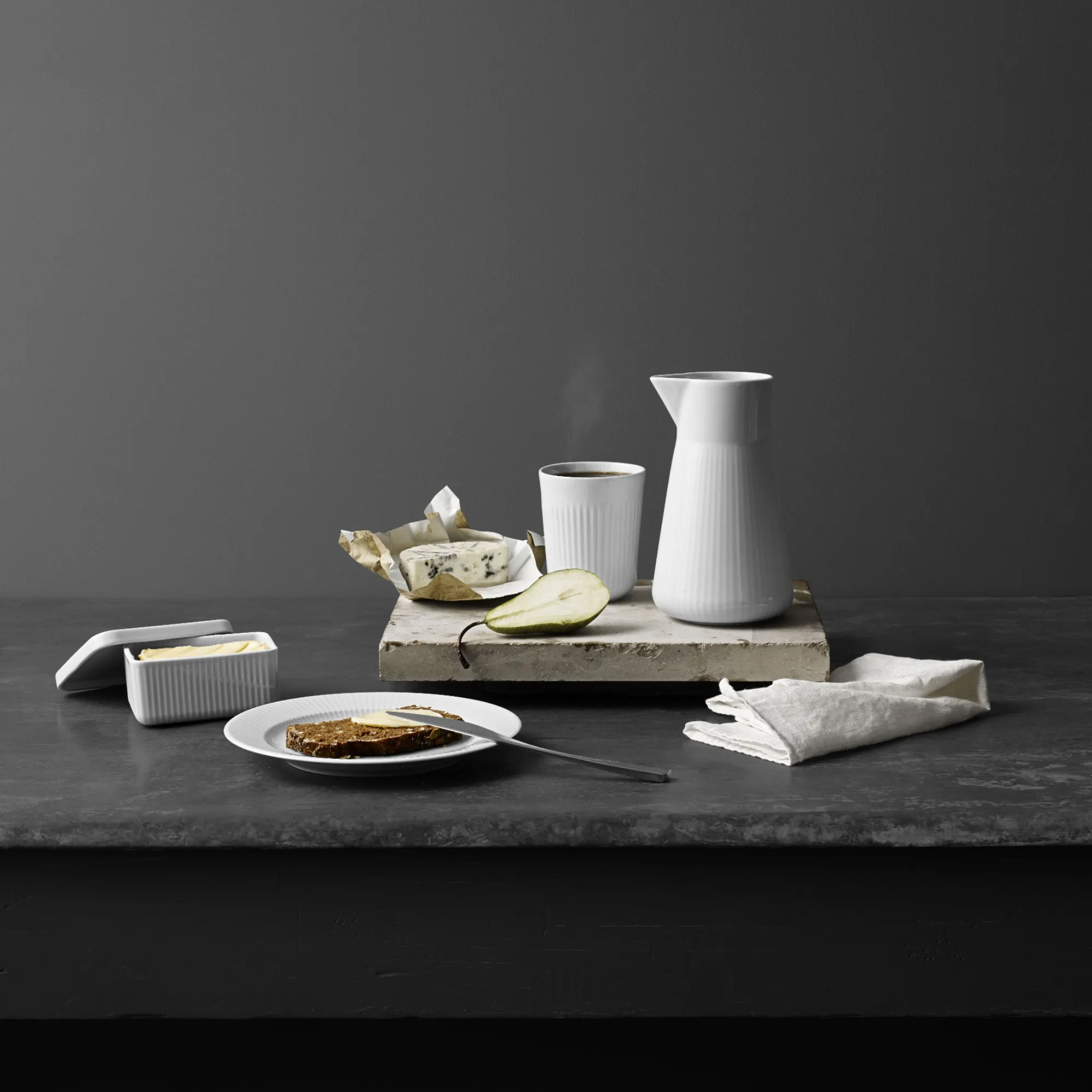 ceramiczny dzbanek, kubek, ser, kromka chleba, gruszka