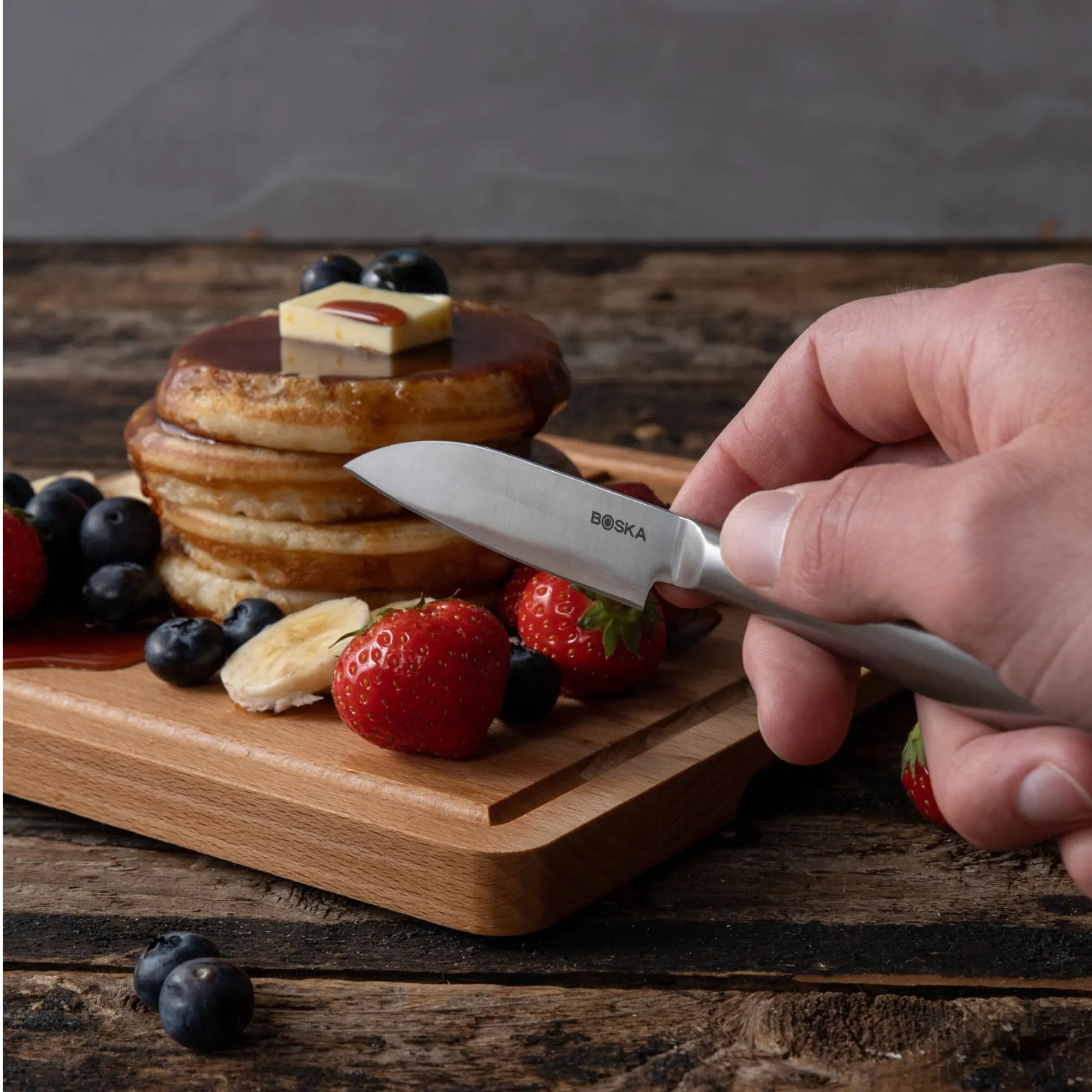 pankejki, masło, jagody, nóż, deska drewniana