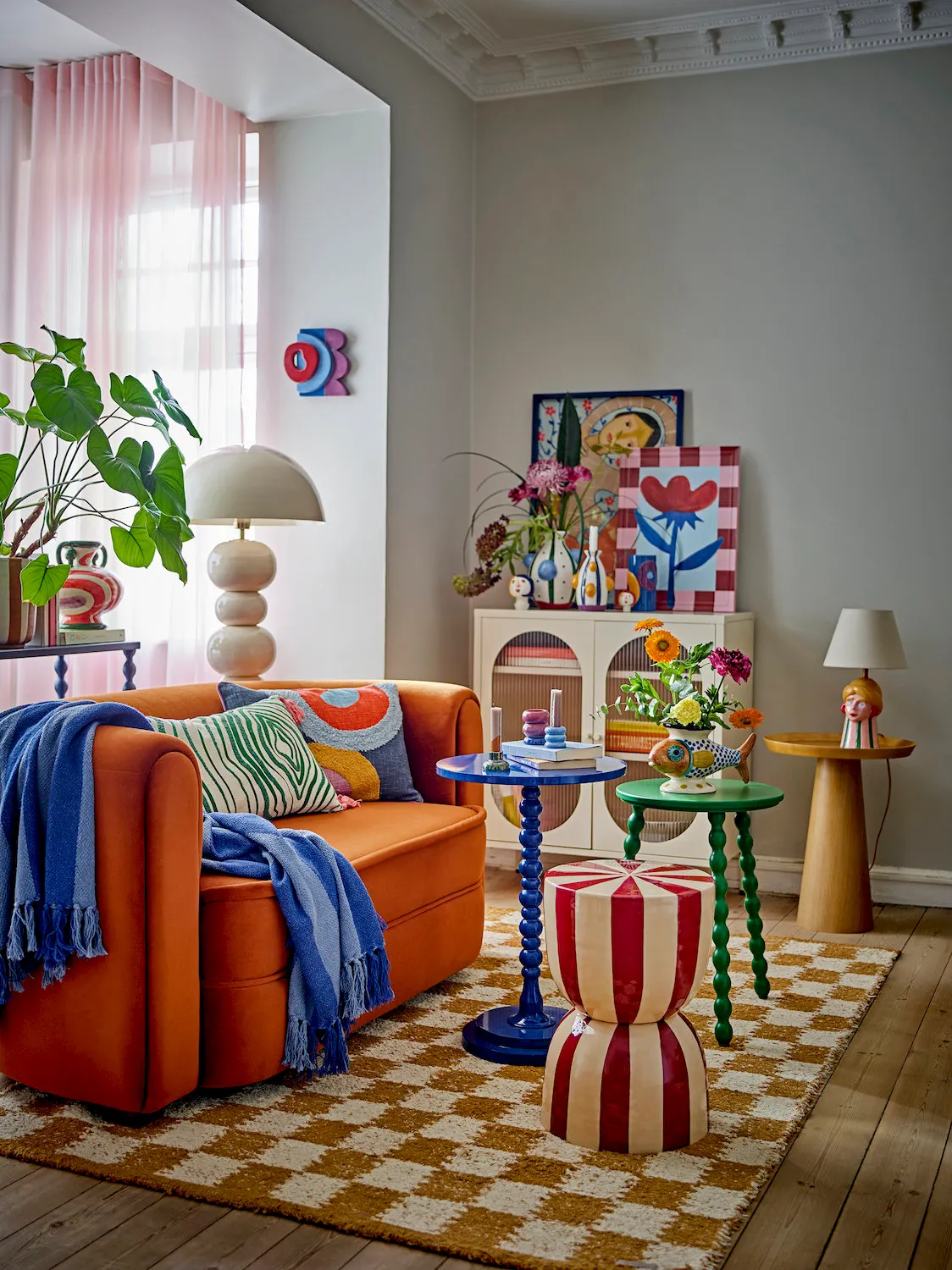 image sofa, sofa pomarańczowa, koc na siedzisku, poduszka floralna, dekoracje do salonu